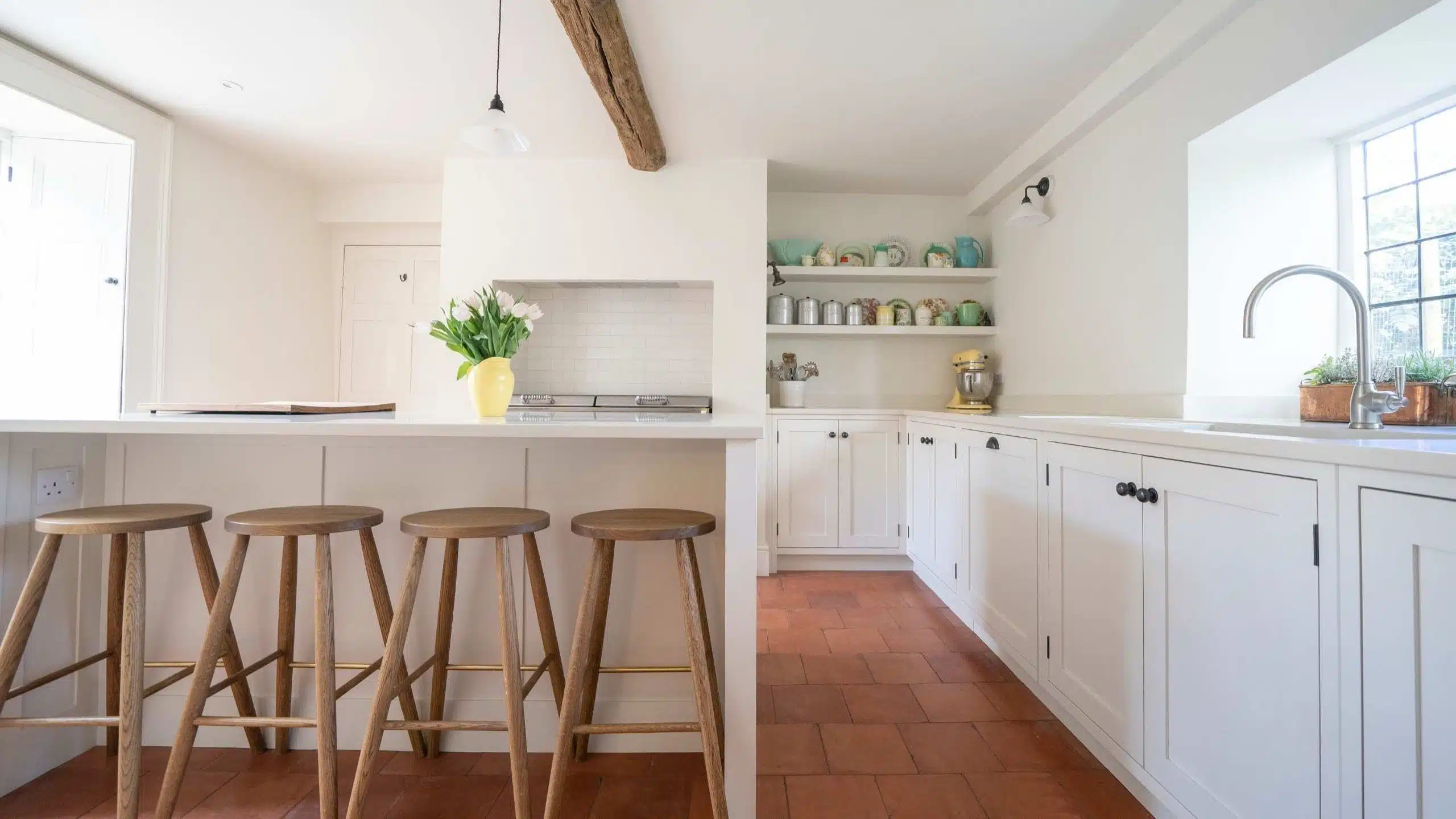 Meiculous Craftmanship - Cherrywood Handmade Luxury Kitchen Bright kitchen with white cabinets, wooden stools, open shelves, and sunlight streaming through the windows.