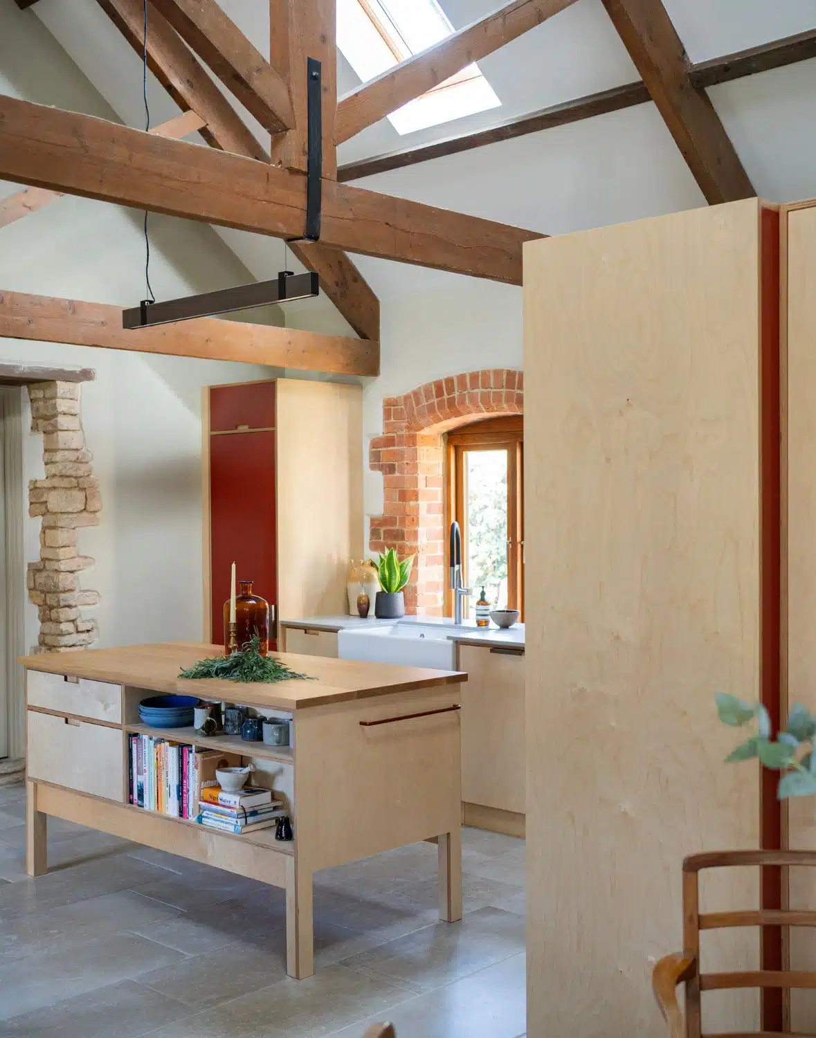 Modern kitchen with green and blue cabinets, open shelves, and a central island.